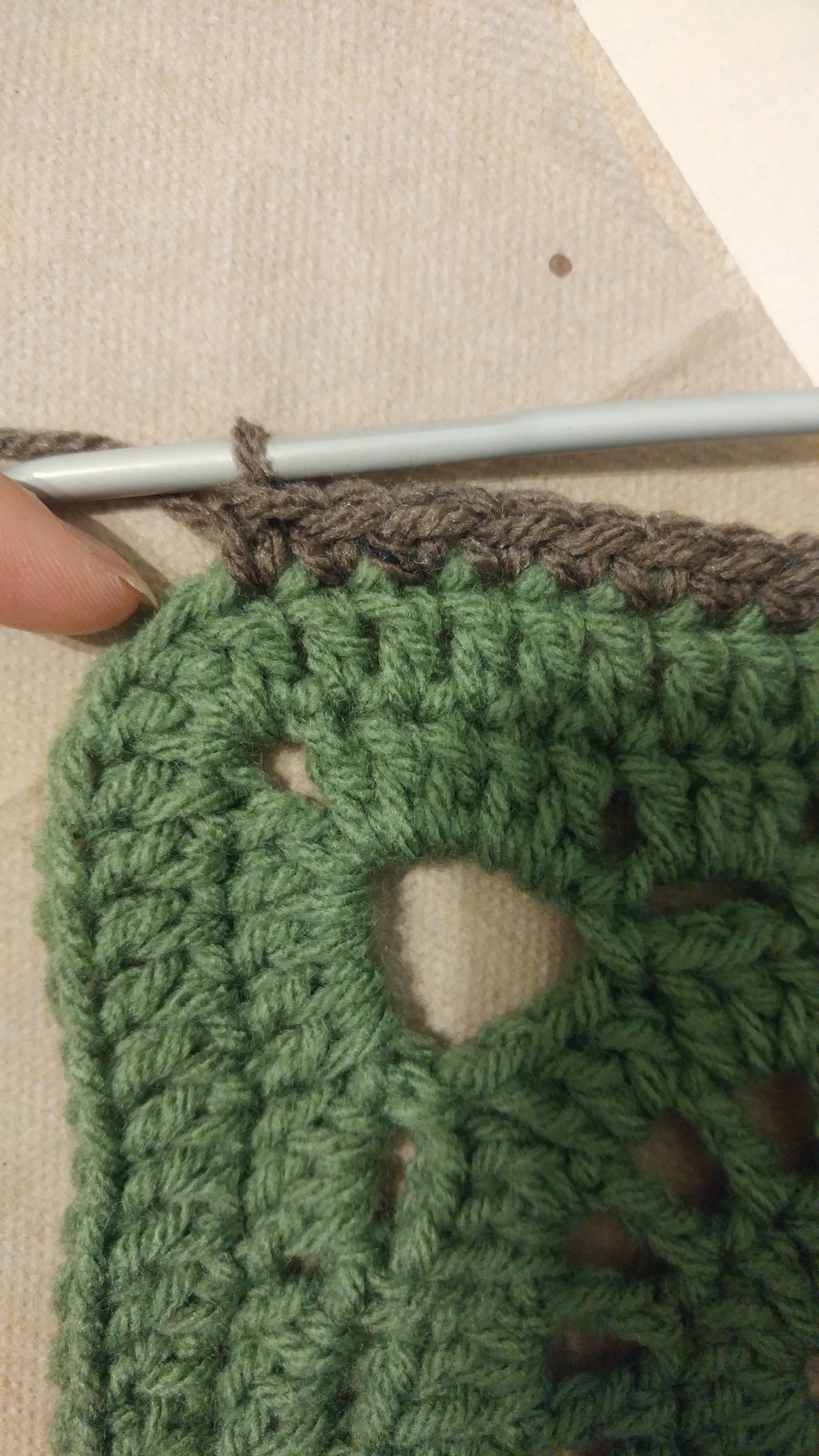 Fancy Square Border Corner Illustration of the top middle of the corner; where my finger is pointing is the stitch that gets two border stitches.